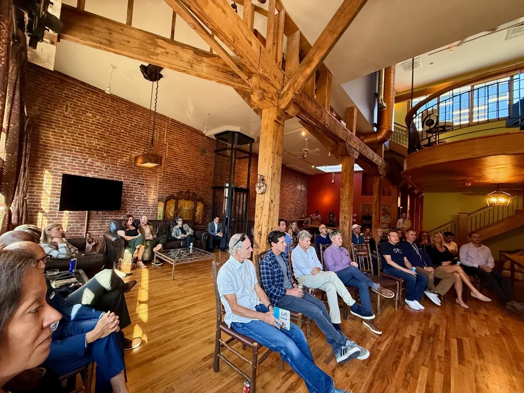 Guests seated beneath the mezzanine at The Reserve, listening to the fireside chat